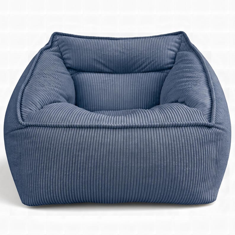 Puede incluir: Un sill&oacute;n tipo puf de pana azul con un dise&ntilde;o estructurado de forma cuadrada. La tela presenta una textura acanalada vertical distintiva en toda la superficie, incluyendo el respaldo, el asiento y los paneles laterales, creando un aspecto uniforme.