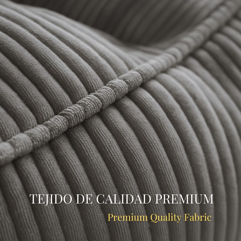 Puede incluir: Un primer plano de tela de pana gris con gruesas nervaduras verticales en relieve y una costura prominente que cruza diagonalmente la superficie. El texto TEJIDO DE CALIDAD PREMIUM y Premium Quality Fabric est&aacute; impreso en blanco y dorado.