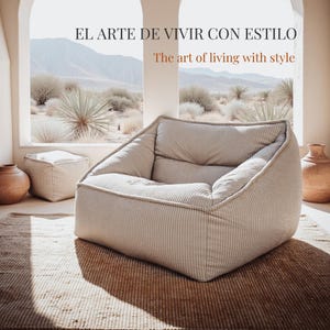 Puede incluir: Un sill&oacute;n lounge beige con textura de pana y una silueta cuadrada de perfil bajo. El texto "EL ARTE DE VIVIR CON ESTILO" y "The art of living with style" aparece sobre el sill&oacute;n en una habitaci&oacute;n luminosa con ventanas arqueadas.