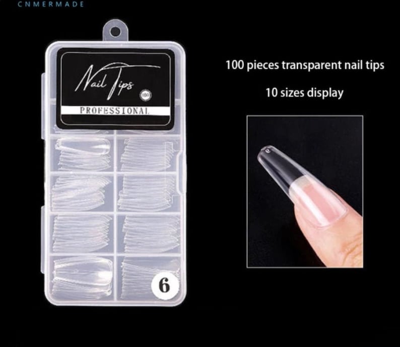 May include: A clear plastic box containing 100 pieces of transparent nail tips in 10 different sizes. The box has a black label that says "Nail Tips Professional".