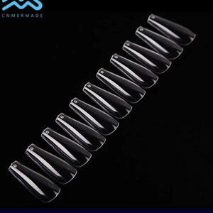 May include: A set of 12 clear, long, coffin-shaped false nails.