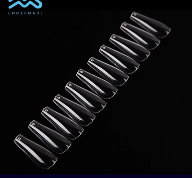 May include: A set of 12 clear, long, coffin-shaped false nails.