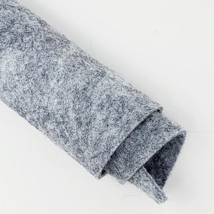 May include: A roll of gray felt fabric with a slightly textured surface.