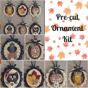 May include: A pre-cut felt ornament kit with a variety of Halloween and fall themes. The kit includes eight ornaments: an owl, a black cat, a pumpkin, a bird, and a leaf. The ornaments are all in a black frame with a white background.