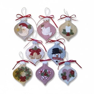 May include: A set of eight teardrop-shaped felt ornaments featuring embroidered holiday motifs including Santa, a dove, a candle, bells, a snowman, a wreath, candy canes, and a heart. Each ornament has a white loop and a red ribbon bow at the top.