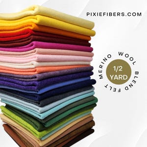 May include: A stack of merino wool blend felt in various colors, including yellow, red, pink, orange, purple, blue, green, and brown. The felt is labeled as 1/2 yard and features the website address PIXIEFIBERS.COM.