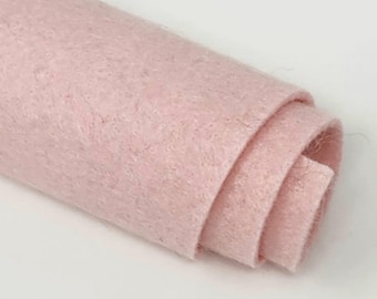 Könnte beinhalten: Eine Rolle hellrosa Filzstoff. Der Stoff ist weich und flauschig.