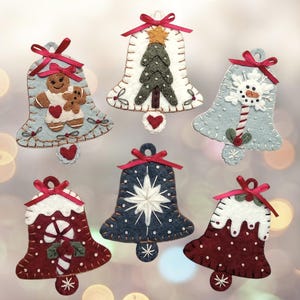 May include: Six felt Christmas bell ornaments with different designs. The bells are white, blue, and red with various embroidery details, including a gingerbread person, a snowman, a candy cane, a Christmas tree, and snowflakes.