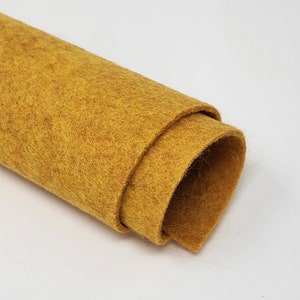 May include: A roll of mustard yellow felt fabric. The felt is soft and has a slightly fuzzy texture.