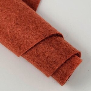 May include: A roll of rust-colored felt fabric. The felt is soft and fuzzy, and it is perfect for crafting projects.