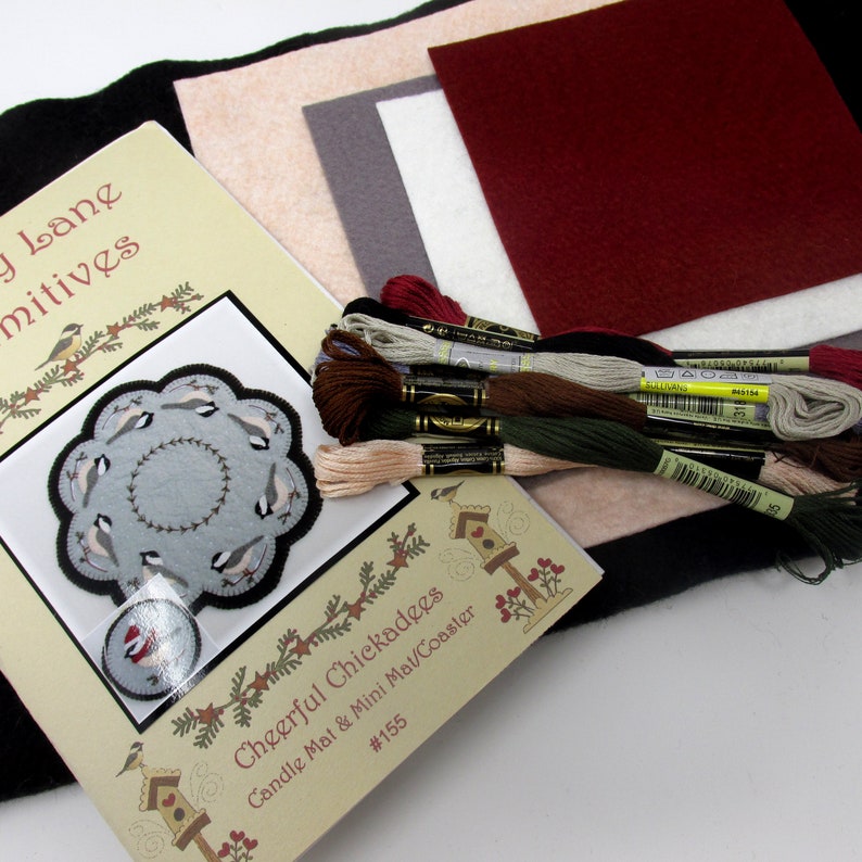 May include: A craft kit for making a cheerful chickadee candle mat or mini coaster. The kit includes a pattern, felt pieces in various colors, and embroidery floss. The pattern shows a circle of birds with a small bird in the center.