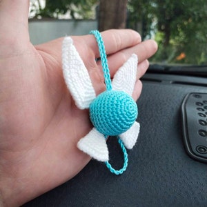 May include: A crocheted blue and white winged charm with a cord for hanging.