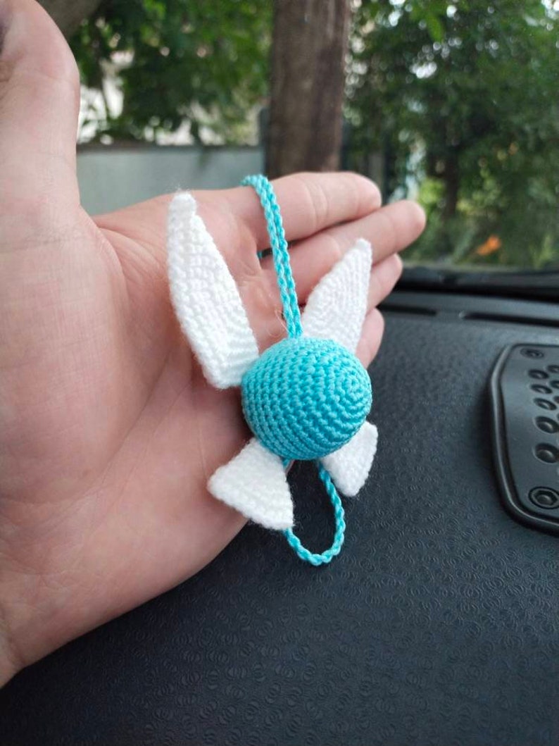 May include: A crocheted blue and white winged charm with a cord for hanging.