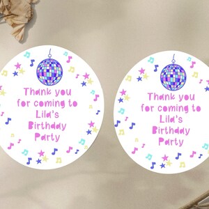 May include: Two round white thank you stickers with a pink disco ball, stars, and musical notes. The text on the stickers reads "Thank you for coming to Lila's Birthday Party".