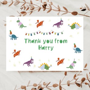 May include: A white thank you card with a green dinosaur theme. The card has a string of colourful lights and the text "Thank you from Harry".