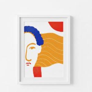 May include: A framed art print featuring an abstract illustration of a face with a blue hair, orange hair, red lips, and a red sun shape. The artwork is in a white frame.