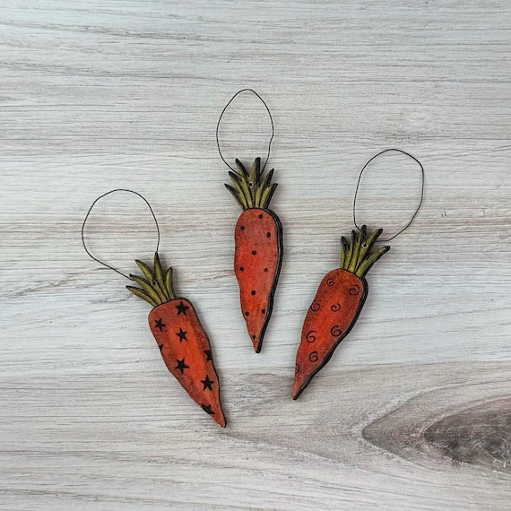 Tiny hand-carved wooden carrots with wire accents that are somehow both absurd and charming — the kind of thing you put on a shelf and everyone asks about.