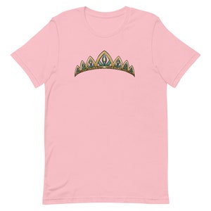 May include: A pink t-shirt with a gold and green crown design.