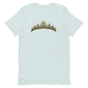May include: A light blue t-shirt with a gold and green crown design.