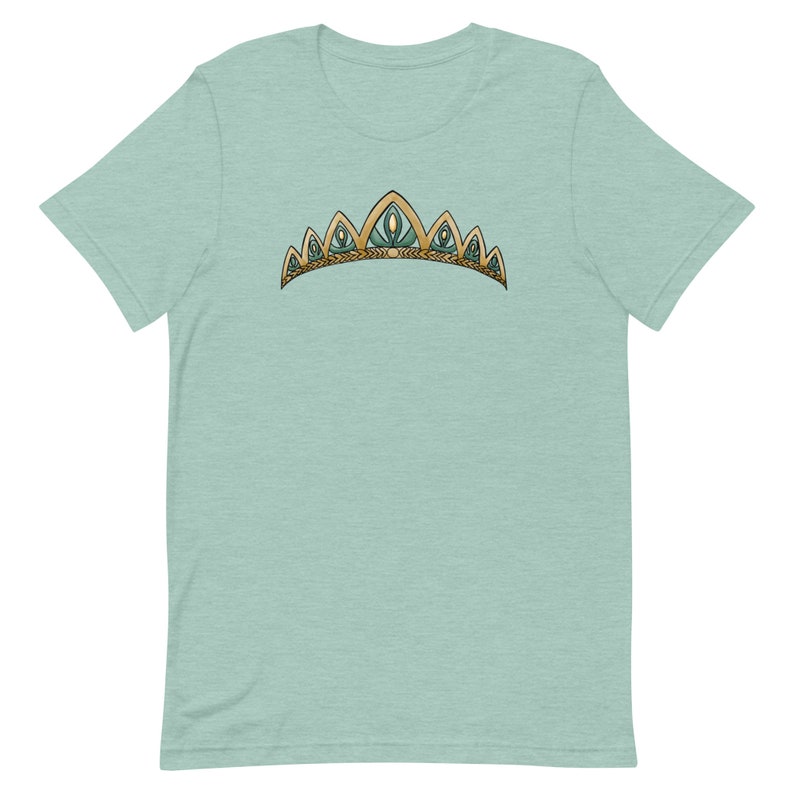 May include: A light blue t-shirt with a gold and green crown design.