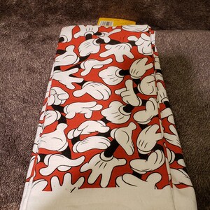 May include: A set of white kitchen towels with a red background and a pattern of black and white Mickey Mouse hands.