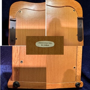 May include: A wooden box with a hinged lid and a small metal plaque that reads "Handcrafted in China". The box has a light brown finish and is decorated with black metal hinges.