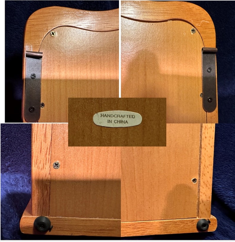 May include: A wooden box with a hinged lid and a small metal plaque that reads "Handcrafted in China". The box has a light brown finish and is decorated with black metal hinges.