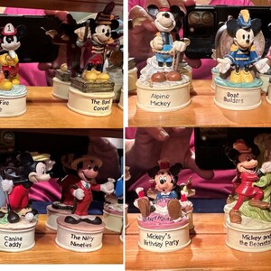 May include: A collection of ten small, colorful, ceramic figurines of Mickey Mouse in various poses and settings. Each figurine is on a small, round base with a different inscription. The inscriptions include "Mickey's Fire Brigade", "The Band Concert", "Alpine Mickey", "Boat Builders", "Fantasia", "Mr. Mouse Takes a Trip", "Canine Caddy", "The Nifty Nineties", "Mickey's Birthday Party", "Mickey and the Beanstalk", and "Simple Things".