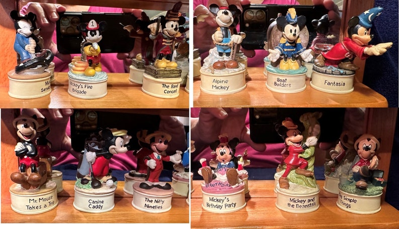May include: A collection of ten small, colorful, ceramic figurines of Mickey Mouse in various poses and settings. Each figurine is on a small, round base with a different inscription. The inscriptions include "Mickey's Fire Brigade", "The Band Concert", "Alpine Mickey", "Boat Builders", "Fantasia", "Mr. Mouse Takes a Trip", "Canine Caddy", "The Nifty Nineties", "Mickey's Birthday Party", "Mickey and the Beanstalk", and "Simple Things".