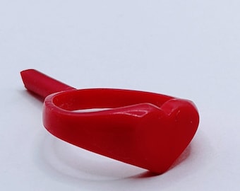 May include: A red plastic ring with a heart-shaped design.