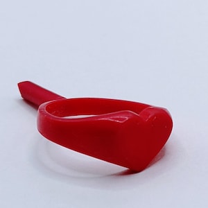May include: A red plastic ring with a heart-shaped design.