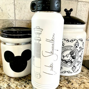 32oz Star Wars Lightsaber Water Bottles. These are laser engraved  with your favorite Jedi Lightsaber and signature like Darth Vader, Luke Skywalker, Obi-Wan Kenobi, Kylo Ren, Ahsoka Tano, and more! These can also be personalized.