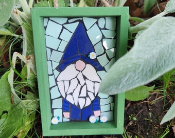 Mosaico de gnomos sobre marco de madera.