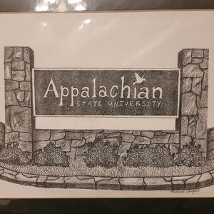 May include: A black and white pencil drawing of the Appalachian State University sign. The sign is made of stone and has a bird flying above it. The text on the sign reads "Appalachian State University".