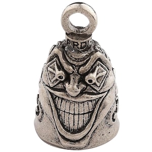 May include: Silver motorcycle handlebar bell with a detailed, grinning, demonic face. The bell has a loop at the top for hanging.