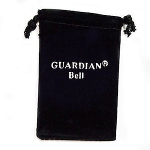 Op de afbeelding: Een zwarte fluwelen zakje met trekkoord met de witte tekst "GUARDIAN Bell". Het zakje is aan de bovenkant gesloten met twee zwarte geknoopte koorden. De achtergrond is wit.