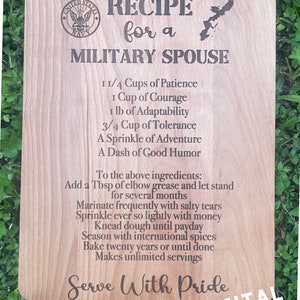 May include: A wooden sign with a recipe for a military spouse. The recipe includes ingredients like patience, courage, and adaptability. The sign also has a United States Navy logo and the text "Serve With Pride".