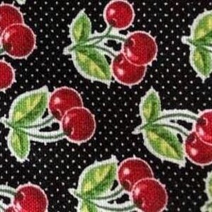May include: Black fabric with a repeating pattern of red cherries with green leaves and white stems on a black background with white polka dots.