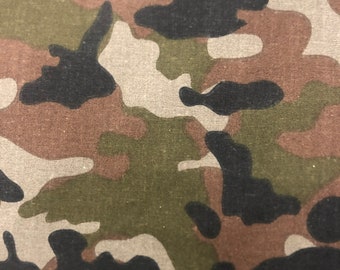 May include: Close-up of a camouflage pattern fabric. The fabric features irregular shapes in shades of black, brown, green, and tan. The pattern is a classic military-style design, suitable for various applications.