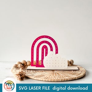 Op de afbeelding: Een roze en witte regenboog en wolk oorbellenhouder met een stippenpatroon. SVG Laser File digitale download.