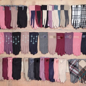 May include: A collection of 40 pairs of women's gloves in various colors and patterns. The gloves are made of a soft, stretchy fabric and feature different embellishments, including pom-poms, stars, and plaid.