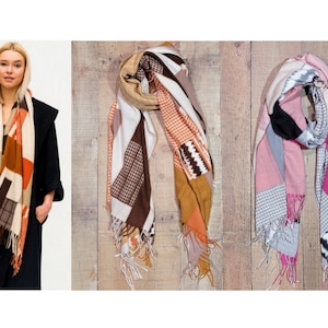 May include: Three patterned scarves with fringe edges. The scarves are in brown, orange, white, pink, gray, and black.