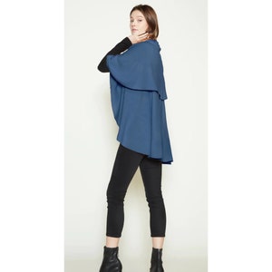 May include: A blue wrap with a high neckline and a long, flowing design. The wrap is made of a soft, comfortable fabric and is perfect for layering.