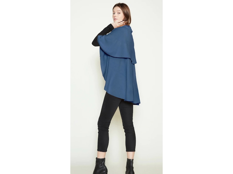 May include: A blue wrap with a high neckline and a long, flowing design. The wrap is made of a soft, comfortable fabric and is perfect for layering.