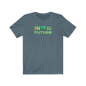 Op de afbeelding: Een donkerblauw t-shirt met de tekst "IN &hearts; WITH MY FUTURE" in een kleurrijk, 3D-lettertype.