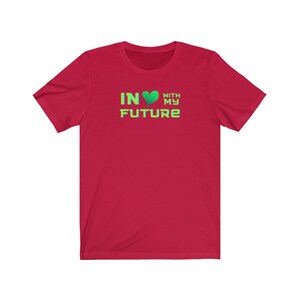 Op de afbeelding: Rood T-shirt met korte mouwen met een groen hart en de tekst "IN &hearts; WITH MY FUTURE" in groen.