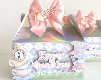 Könnte beinhalten: Eine rosa und weiße Geschenkbox mit einer rosa Schleife und einem Schlüsselanhänger. Die Box hat ein kariertes Muster und sagt "Khalesy in Onderland" mit einer Illustration von Teetasse und Teekanne. Die Box hat auch ein Schild, auf dem steht "This Way to Wonderland, Tea Party, Somewhere".