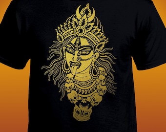 Könnte beinhalten: Ein schwarzes T-Shirt mit einem goldenen Aufdruck einer hinduistischen Göttin mit einer Krone aus Schädeln. Die Göttin ist mit einem grimmigen Ausdruck und einer langen Zunge dargestellt.