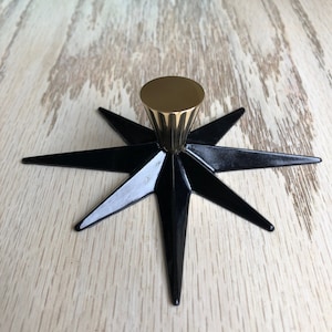 May include: A black star-shaped cabinet knob with a gold-toned, fluted, round top.