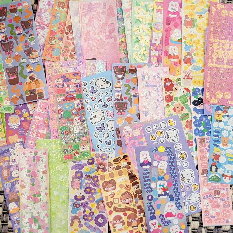 May include: A collection of colorful sticker sheets featuring various cute cartoon characters, animals, and designs. The stickers are perfect for decorating planners, journals, laptops, and other items.